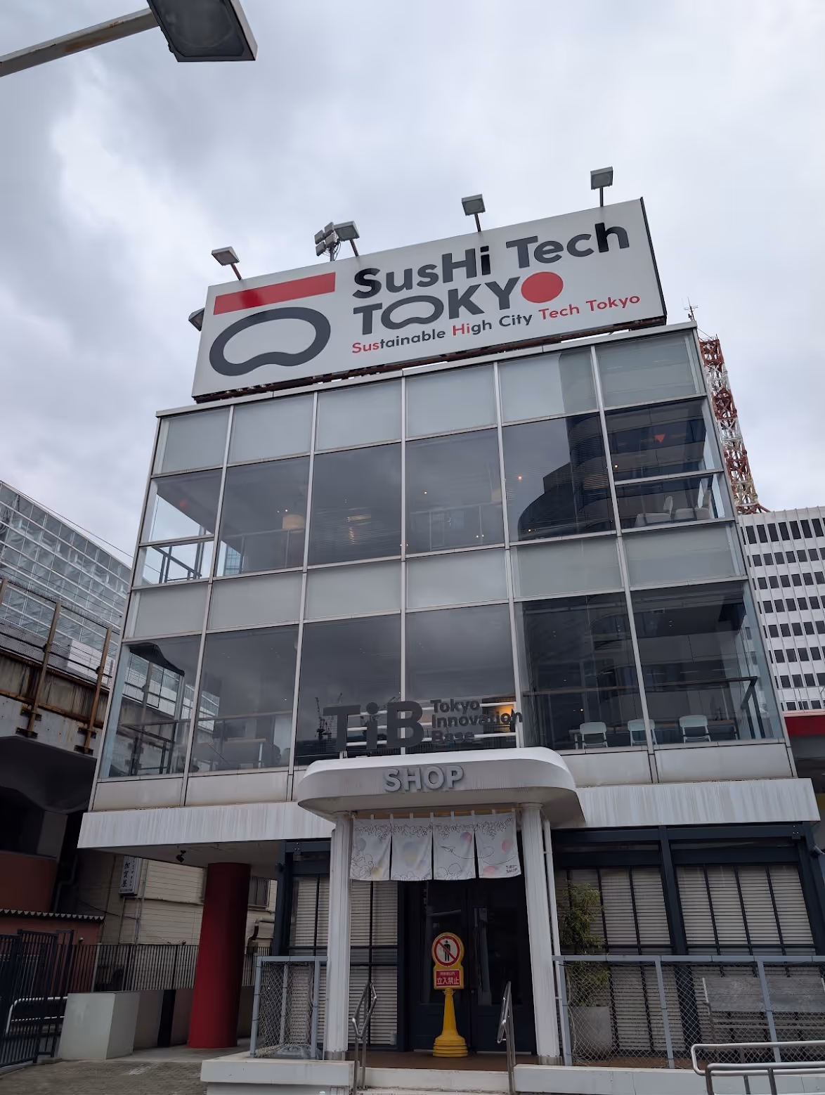 Przeszklony budynek Tokyo Innovation Base z szyldem SusHi Tech Tokyo
